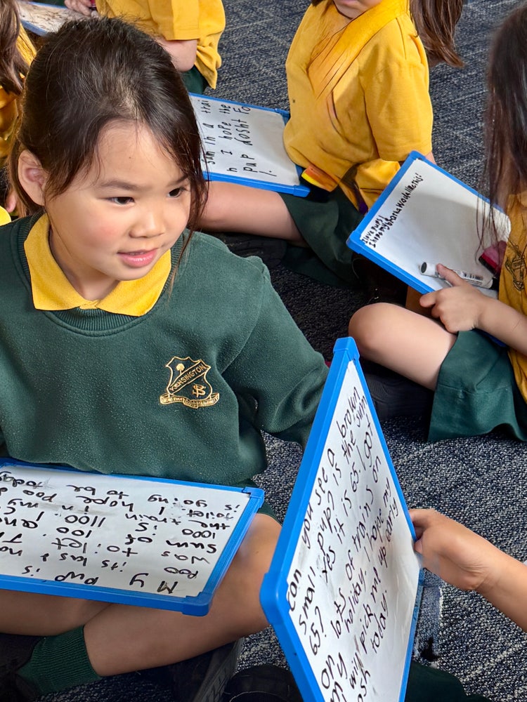 Student writing on mini whiteboard